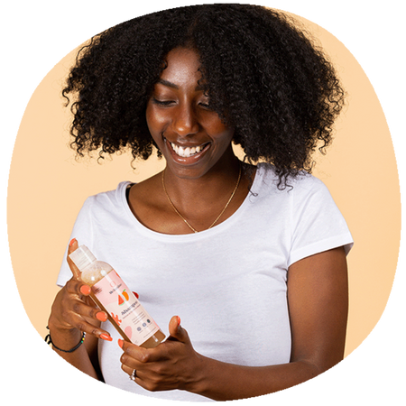 Fille tenant un shampoing pour cheveux afro
